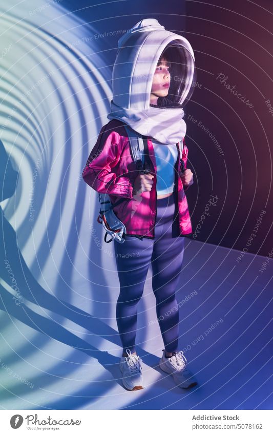 Ruhige Frau im Raumanzug Helm in Neonlicht Chinesisch Schutzhelm Astronaut träumen behüten Kosmonaut Konzept Tierhaut Windstille emotionslos futuristisch