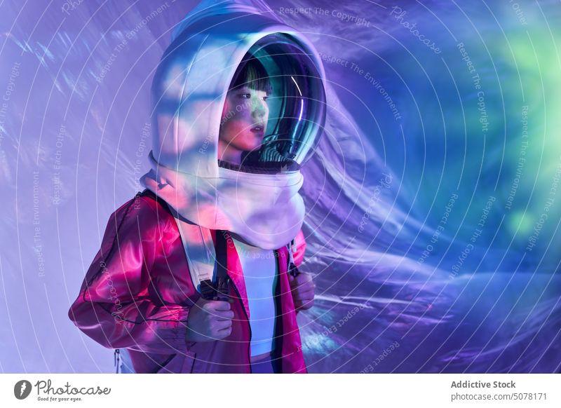 Ruhige Frau im Raumanzug Helm in Neonlicht Chinesisch Schutzhelm Astronaut träumen behüten Kosmonaut Konzept Tierhaut Windstille emotionslos futuristisch