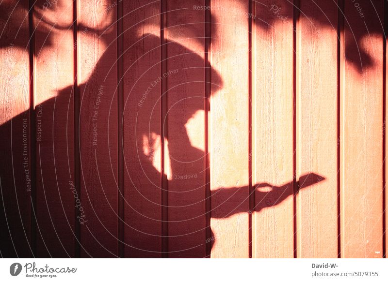 Schatten einer Frau mit Handy in der Hand Smartphone Abhängigkeit Technik & Technologie digital Sonnenlicht Suchtverhalten Mobile anonym