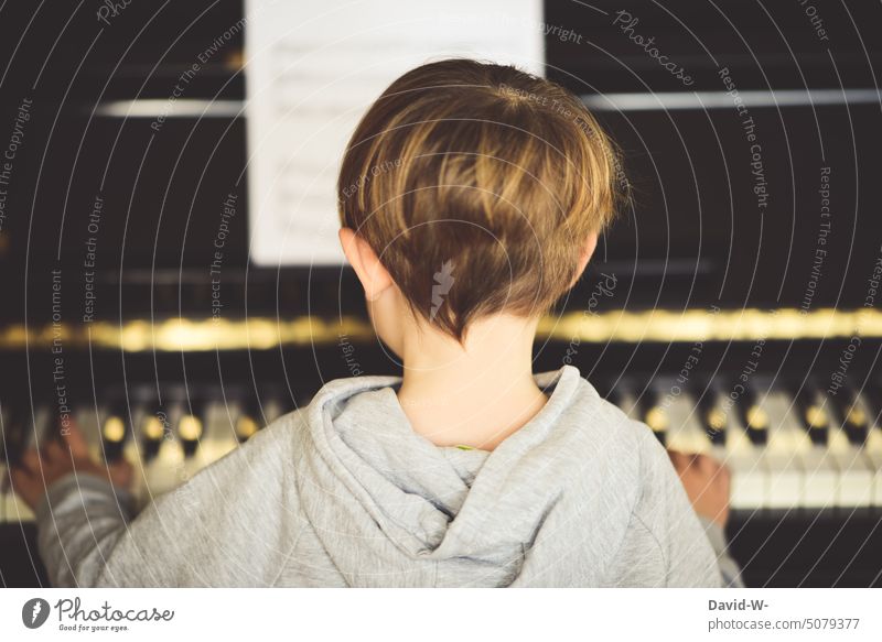 Musik machen - Kind spielt Klavier Junge Musikinstrument spielen Musiker Musikunterricht üben diszipliniert jung