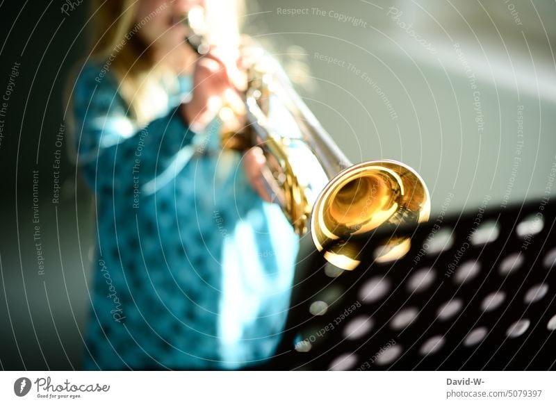 Kind musiziert mit der Trompete Musikinstrument musikschule üben Konzentration Spielen hobby Mädchen notenständer musizieren