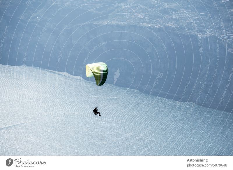 Paragleiter in den Bergen paragliden Paragleitschirm Paragleiten Gebirge Gardasee Monte Baldo Schatten 2 hoch oben schweben Fliegen dunkel Landschaft hochoben