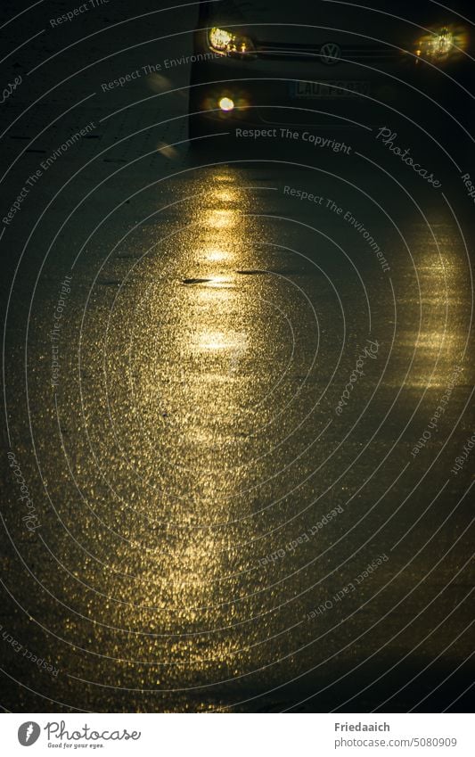 Autoscheinwerfer auf nass glänzender Asphaltstraße Straße Scheinwerfer Licht PKW Abend Verkehr dunkel Glanz Straßenverkehr Nieselregen Autofahren goldglänzend