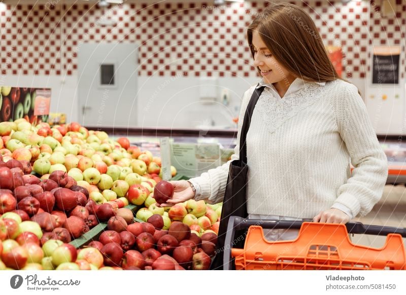 Frau kauft Obst und Gemüse auf einem Markt, Apfel Supermarkt Laden Kunde Frucht Lebensmittel Korb Karre Verbraucher Lebensmittelgeschäft Menschen Einzelhandel