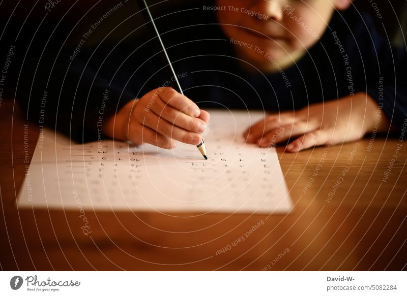 Kind macht Hausaufgaben rechnen Mathematik lernen üben Stift Junge Schule Bildung zuhause Zettel Freude Spaß Hand Schreibtisch Motivation fleißig konzentriert