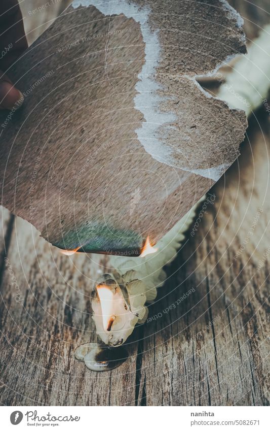 Papierkarte Mockup brennt mit Kerze Flamme gegen altes Holz Textur Hintergrund Feuer Attrappe Hinweis altehrwürdig gealtert Handwerk Oberfläche Korn romantisch