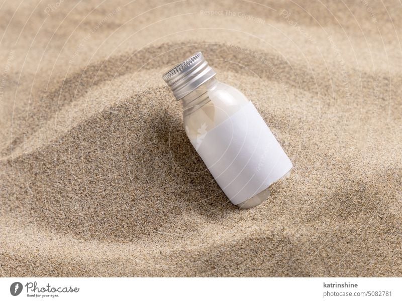 Leere Cremeflasche auf beigem Sand in Großaufnahme. Kosmetische Attrappe Flasche weiß blanko Kosmetik abschließen Paket natürlich Hautpflege Spa