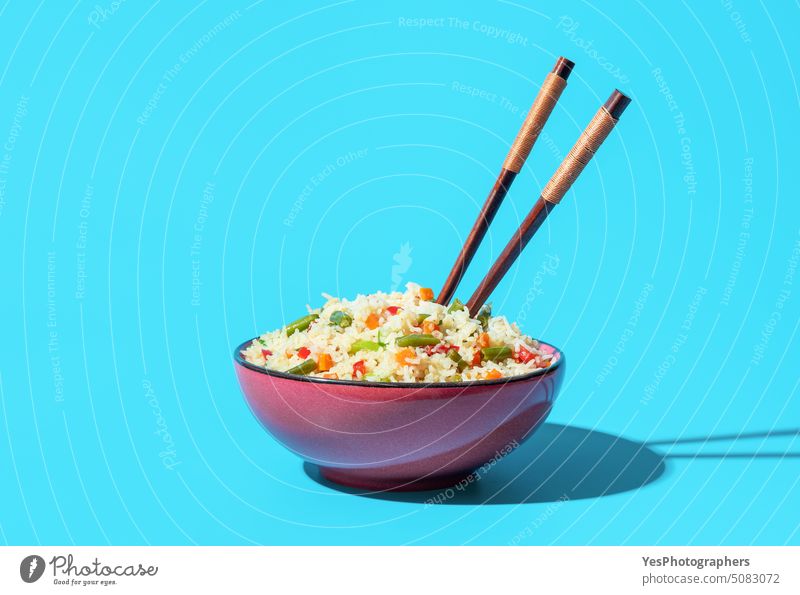 Schüssel mit gebratenem Reis und Gemüse minimalistisch auf einem blauen Hintergrund asiatisch Bohnen Schalen & Schüsseln hell Möhre Chinesisch Essstäbchen