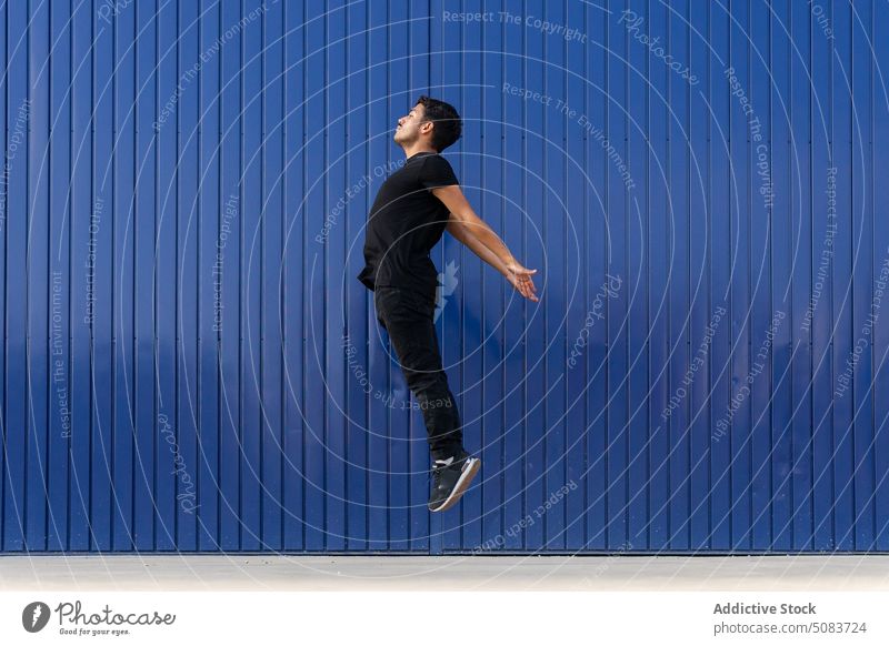 Mann springt gegen blauen Zaun springen Gleichgewicht aktiv schweben üben Tänzer Energie ausführen sich[Akk] bewegen Talent Konzentration Straßenbelag Fähigkeit