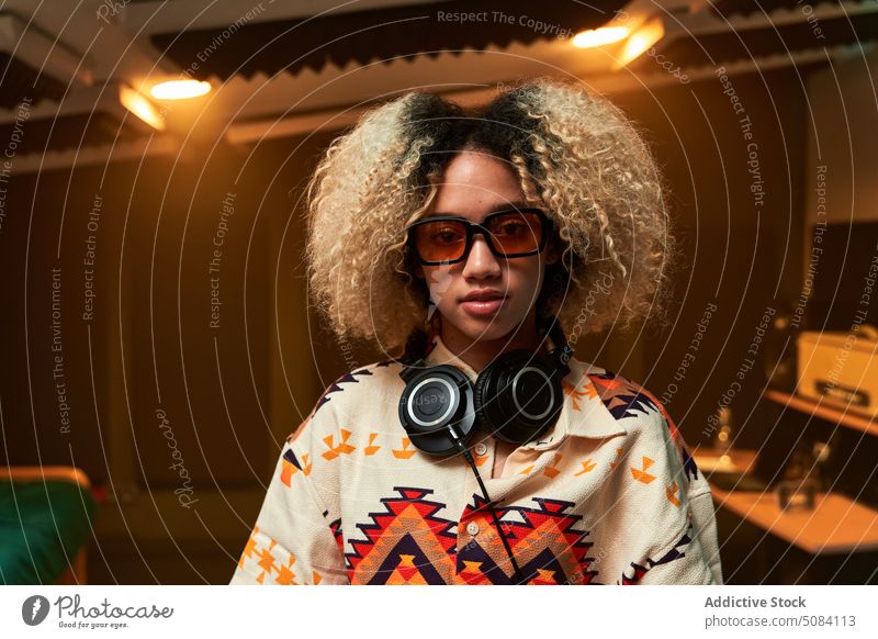 Ethnische Frau mit Kopfhörern im Nacken Porträt Musiker Atelier genießen unterhalten Kälte Persönlichkeit akustisch Gesang Gerät stereo Audio Inszenierung