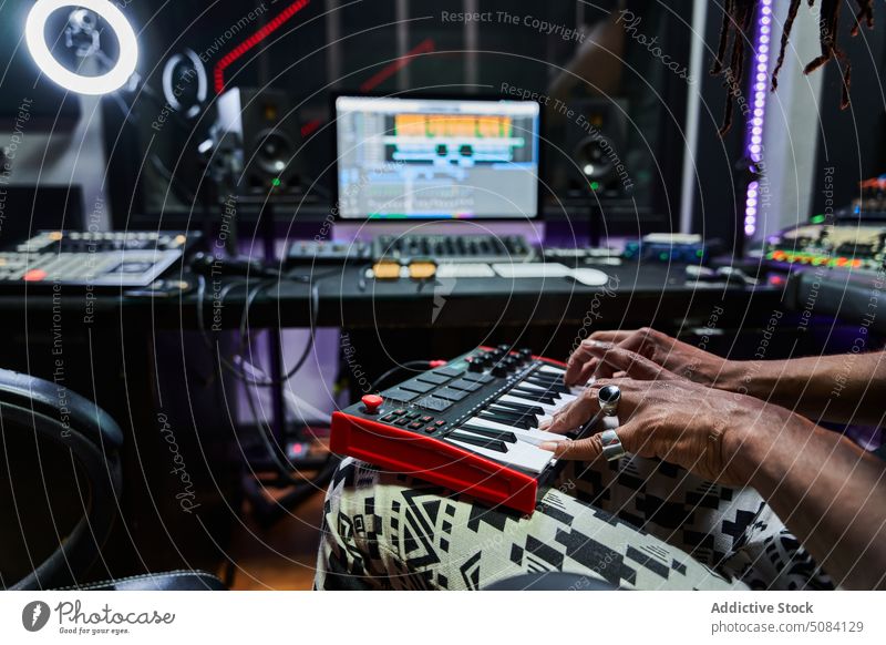 Anonymer schwarzer Mann spielt Synthesizer in einem modernen Aufnahmestudio Musiker spielen Aufzeichnen Atelier Talent Probe üben Konzentration Typ kreativ