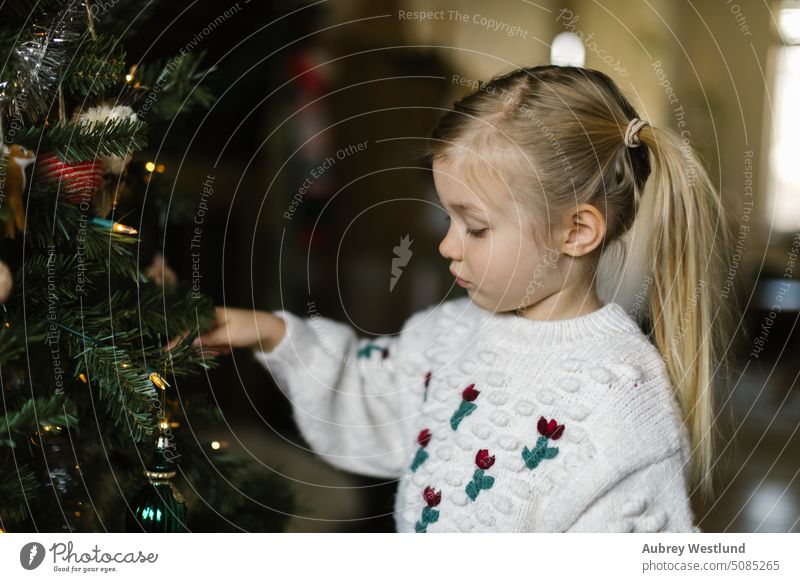 Kleines Mädchen mit Zöpfen schmückt einen Weihnachtsbaum Weihnachtsmann Hintergrund blond hell Feier Kind Kindheit Weihnachten niedlich Dezember dekorierend