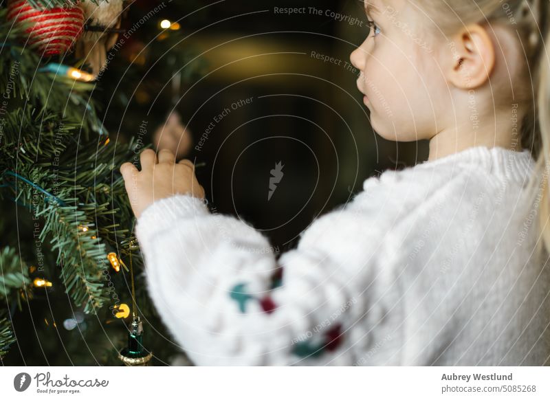 Kleines Mädchen mit Zöpfen schmückt einen Weihnachtsbaum Weihnachtsmann Hintergrund blond hell Feier Kind Kindheit Weihnachten niedlich Dezember