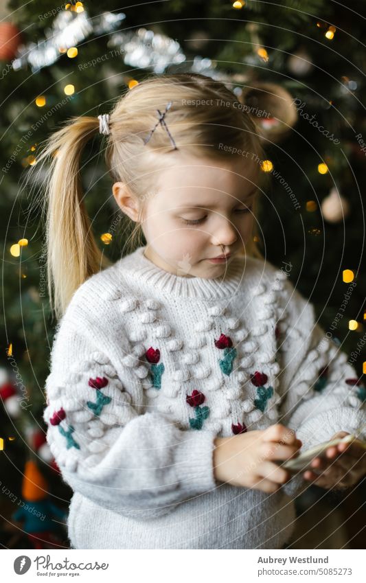 Kleinkind Mädchen mit Zöpfen spielen mit Ornamenten aus einem Weihnachtsbaum Weihnachtsmann Hintergrund blond hell Feier Kind Kindheit Weihnachten niedlich