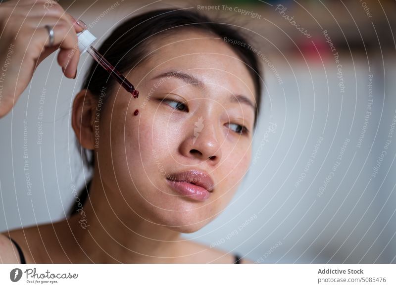 Asiatische Frau trägt Rouge auf die Wange auf bewerben Kosmetik Tropfen Deckung erröten Sahne Make-up Gesichtsbehandlung Pipette asiatisch Schönheit sanft