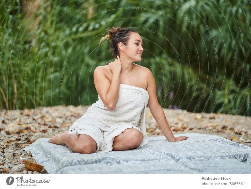 Frau im Handtuch sitzt auf Matte im Park Decke Unterlage Harmonie sich[Akk] entspannen nackt Lächeln Natur Sommer Pflanze tropisch Glück Tasthals Optimist grün