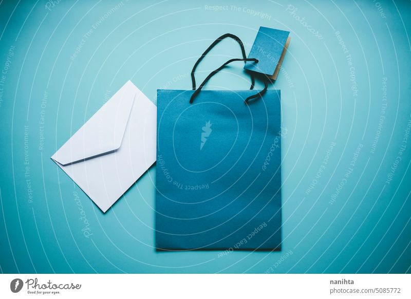 Flat Lay Mockup in kalten Tönen mit einem weißen Umschlag und einer blauen Geschenktüte Attrappe flache Verlegung Tasche Hintergrund cool Kuvert blanko Kopie