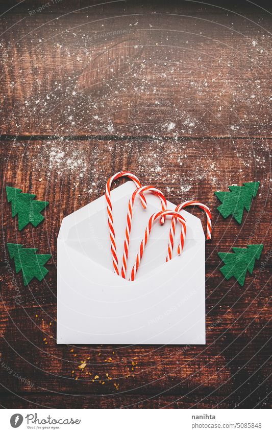 Weihnachtsflatlay mit einem Umschlag voller Zuckerstangen vor einem rustikalen Holzhintergrund Weihnachten Attrappe Hintergrund flache Verlegung Kuvert hölzern