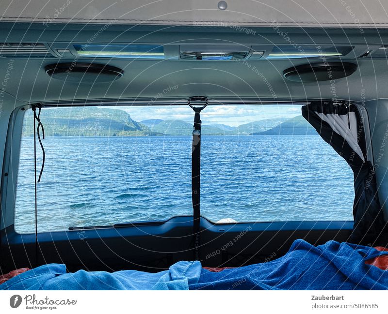 Blick aus der Heckscheibe eines Campervans auf einen See beim Vanlife oder Camping in Norwegen Bett Handtücher Bulli Wellen Morgen aufwachen Idylle Stellplatz