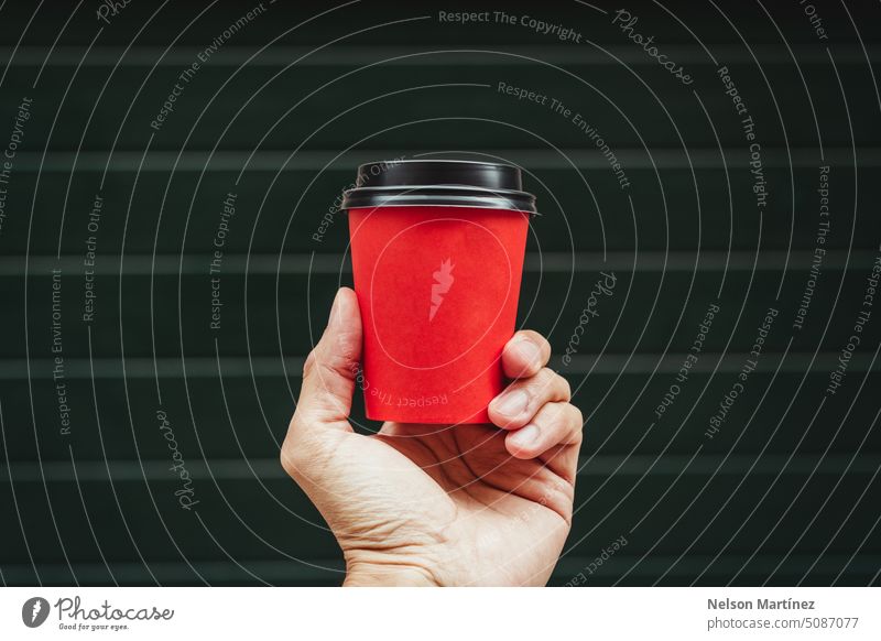 Hand eines Mannes, der einen roten Pappbecher Kaffee hält Getränk vereinzelt Hintergrund Nahaufnahme Cappuccino Tasse trinken Heißgetränk Lebensmittel Becher