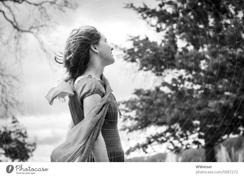 Ein junges Mädchen genießt den Wind, der Haare und Schal flattern lässt windig Natur draußen junge Frau Teenager genießen Luft Böe stürmisch Windstärke wehen