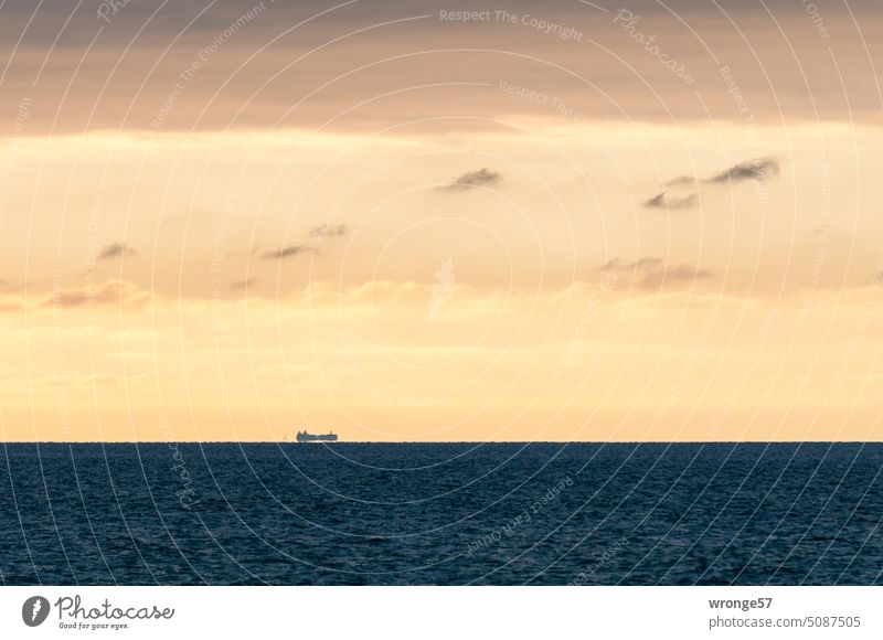 Ein am Horizont in der heißen flimmernder Luft kaum zu erkennender Frachter mit Kurs aufs Festland Meer Ostsee Abendhimmel Hitze flimmernde Luft Ferne Himmel