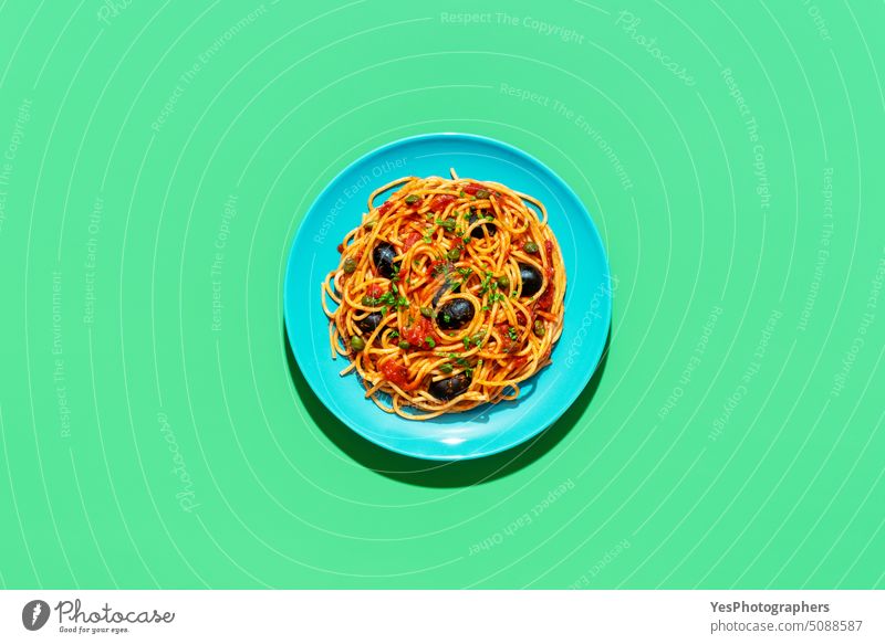Spaghetti puttanesca Teller, Ansicht von oben auf grünem Hintergrund hell Kapriolen Kohlenhydrate Farbe gekocht Textfreiraum kreativ Küche ausschneiden lecker