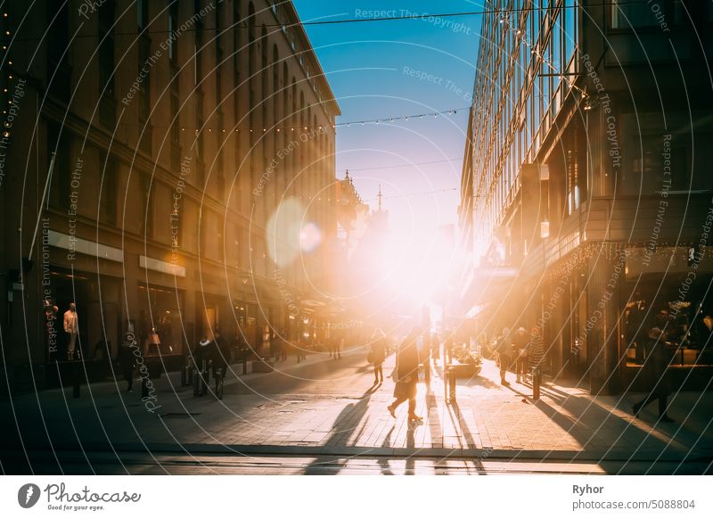 Helsinki, Finnland. Menschen zu Fuß auf Kluuvikatu Straße im Winter Sonnenlicht. Straße dekoriert für Weihnachten und Neujahr Urlaub Haus Laden Finnisch