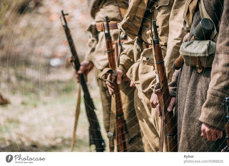 Close Up von Re-enactors gekleidet als sowjetische Infanterie Soldaten des Zweiten Weltkriegs hält Gewehre Waffen in den Händen. Russische Soldaten Standing Order