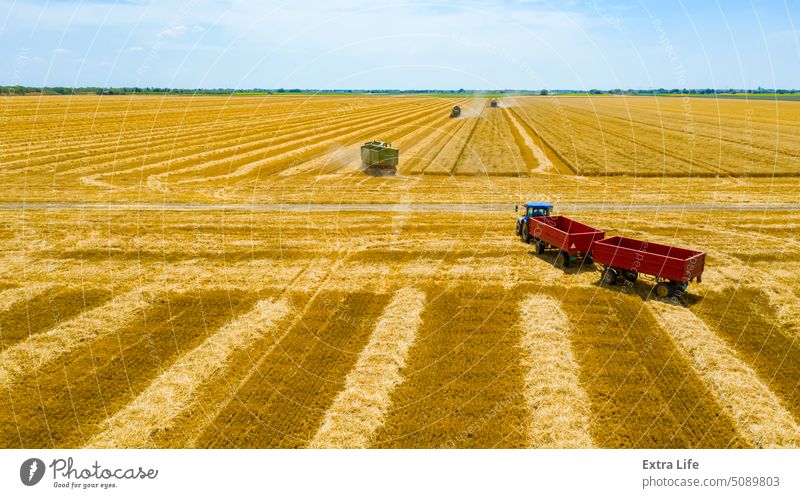 Blick von oben auf die Erntezeit auf einem landwirtschaftlichen Grundstück, Mähdrescher bei der Weizenernte, Traktorschlepper Antenne Ackerbau Müsli Land