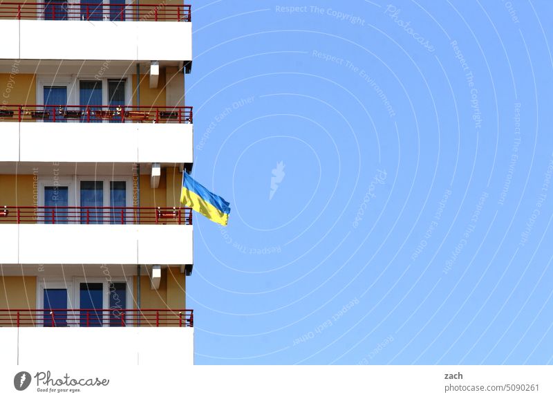 Solidarität zeigen Fahne Ukraine Ukrainekrieg Flagge ukrainische Flagge Haus Fassade Plattenbau blau gelb Hochhaus Himmel Frieden Krieg Zeichen