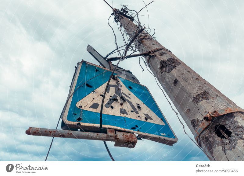 ein von Scherben zerbrochener Betonpfeiler und ein Straßenschild vor einem düsteren Himmel Kherson kyiv Lugansk mariupol Russland Ukraine Saporoschje aussetzen