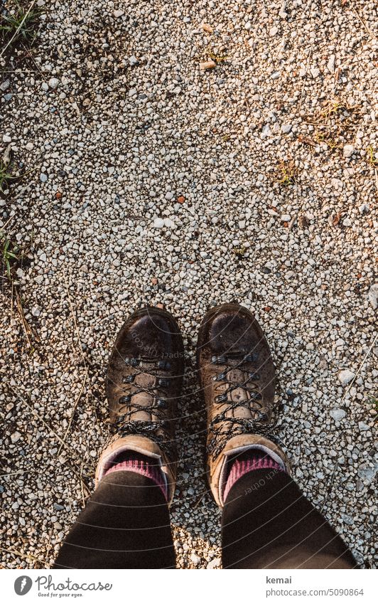 Füße in Wanderstiefeln von oben Schuhe Wanderschuhe Vogelperspektive braun Leder Lederstiefel Lederschuhe Socken Leggins Wandern Outdoor Kies Straße Steine