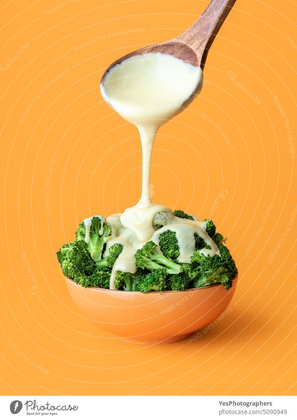 Brocolli mit Cheddar-Käse-Gericht. Geschmolzener Käse wird über den gekochten Brokkoli gegossen. Überfluss Hintergrund Schalen & Schüsseln Nahaufnahme Farbe