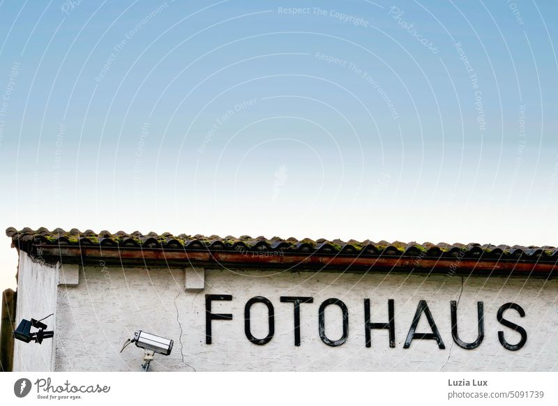 Fotohaus - Schriftzug und Videoüberwachung vor halbwegs blauem Himmel Architektur architektonisch Architektur und Gebäude Beschriftung Videokamera Überwachung
