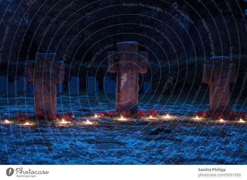 Steinkreuze inder blauen Stunde mit Kerzenschein als Gedenkstätte Kreus Erinnerung Tod Trauer Friedhof Traurigkeit Außenaufnahme ruhig Vergänglichkeit