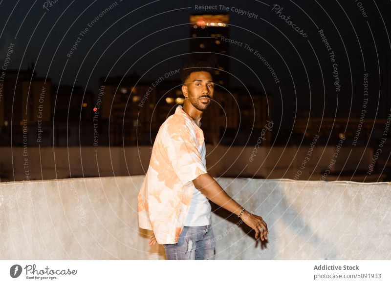 Schwarzer Mann geht nachts nach draußen Spaziergang Großstadt Straße Beton Borte selbstbewusst Nacht schlendern urban männlich jung Afroamerikaner schwarz