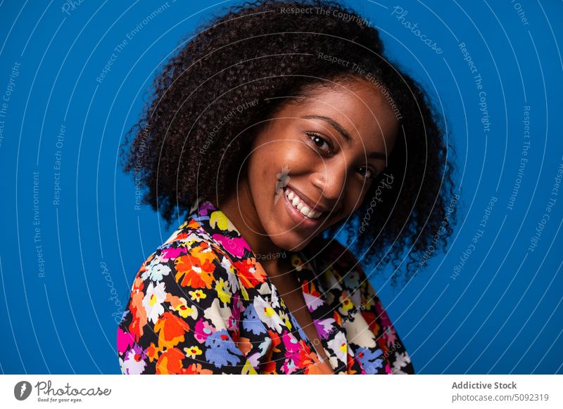 Glückliche schwarze Frau lächelnd im Studio Lächeln Stil krause Haare Model farbenfroh jung Afroamerikaner ethnisch positiv Optimist Freude Outfit Hemd Rock