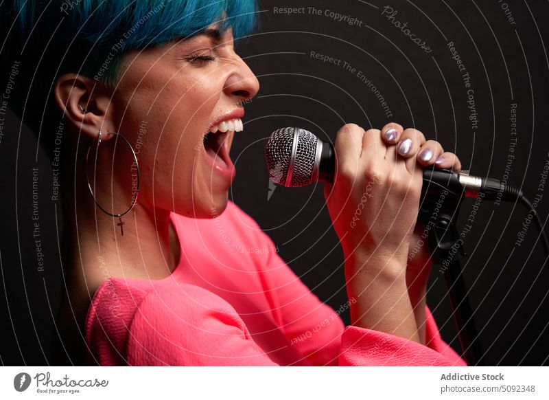 Junge Frau singt ins Mikrofon singen Gesang Sänger Musik ausführen Stil Talent Fähigkeit Augen geschlossen Stimme Klang jung Melodie lässig Gerät laut