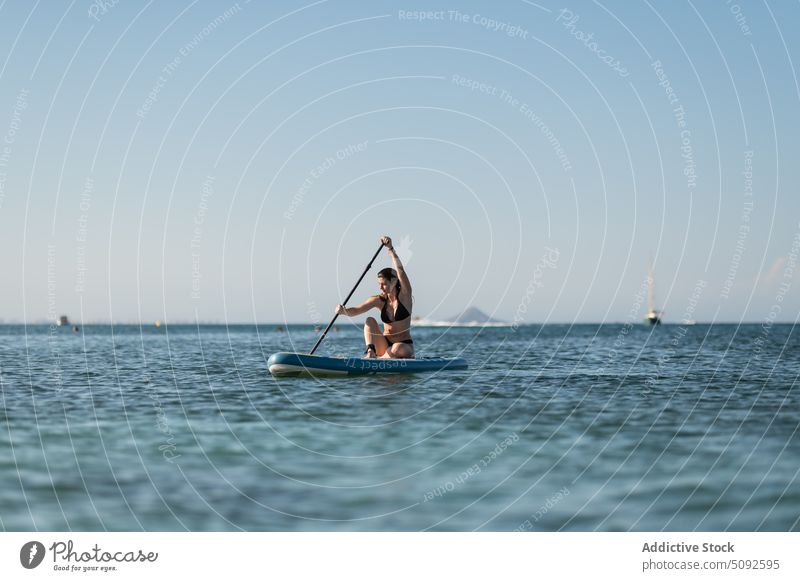Tourist rudert auf einem Surfbrett im Meer Reihe Schwimmer Zusatzplatine MEER Paddelbrett Rippeln Wasser ruhig wolkenlos Frau Himmel Hobby Natur Sommer