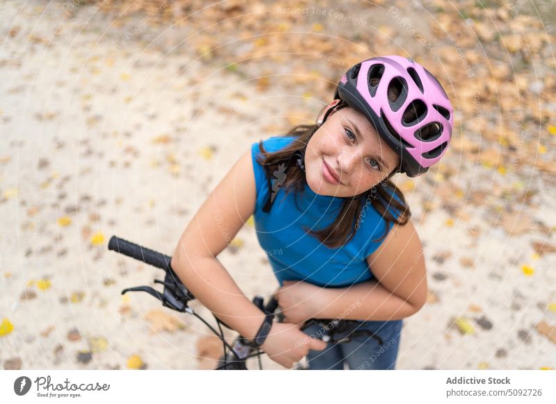 Glückliches Mädchen lehnt am Fahrradlenker anlehnen Lenker Kind Herbst Park Hobby Sicherheit Zyklus Freude Lächeln jung aktiv Adrenalin extrem Wald