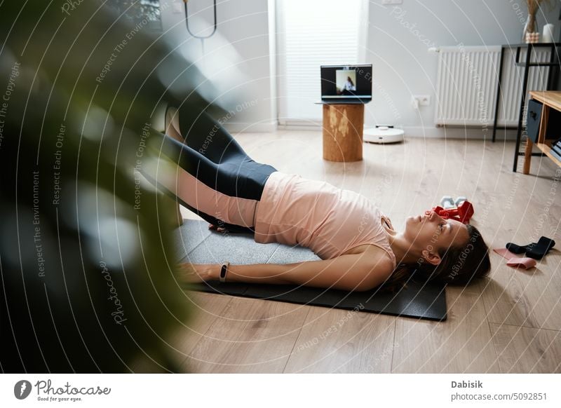 Frau in Sportkleidung macht Fitness- und Kardioübungen zu Hause, mit Laptop Training heimwärts Aktivität abgelegen mental Entfernung online aktiv Körper