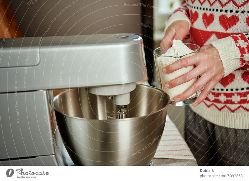 Frau, die zu Hause in der Küche kocht, benutzt einen elektrischen Mixer zur Zubereitung von Teig Essen zubereiten Geräte Rezept Feiertag Weihnachten Cookies