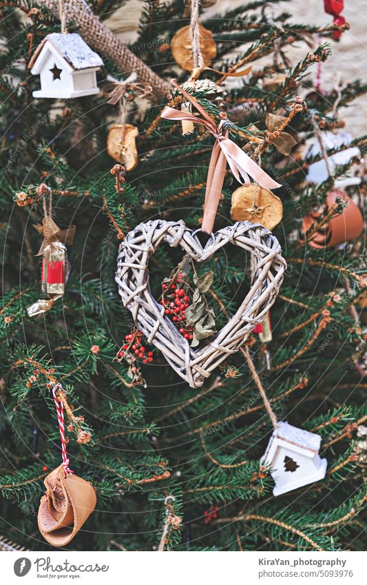 Weihnachtsbaum geschmückt mit einem geflochtenen Kranz in Herzform und anderem handgemachten Weihnachtsschmuck ohne Abfall Weihnachten Baum Totenkranz