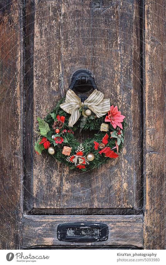 Weihnachtskranz auf einer alten Holztür. Traditionelle Heimdekoration zu Weihnachten Totenkranz Tür Dekoration & Verzierung natürlich altehrwürdig diy festlich