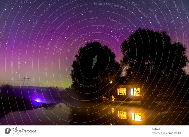 Nächtliche Landschaft mit Nordlicht am grün-violetten Sternenhimmel in Krimulda, Lettland Astronomie Aurora schön Schönheit in der Natur borealis farbenfroh