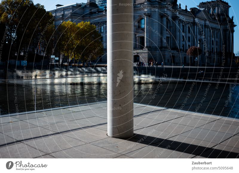 Blick auf eine Säule vor dem Spreeufer, dahinter der Reichstag, im Berliner Regierungsviertel Bundestag Schatten symmetrisch Symmetrie Linien sonnig