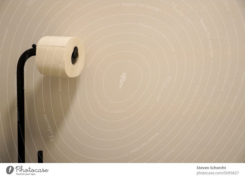 Toilettenpapier auf schwarzem Ständer vor weißer Wand Bad Papier Rolle Sauberkeit Menschenleer Klopapier Körperpflege Innenaufnahme Häusliches Leben