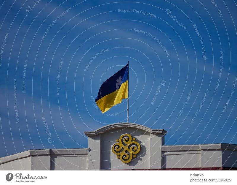 Die gelb-blaue Flagge der Ukraine weht auf einem Gebäude in Kherson gegen den blauen Himmel Mast Freiheit übersichtlich Land Kultur Osten Östlich Europa