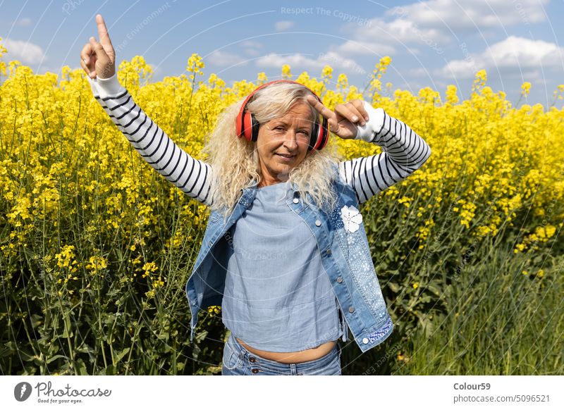 Ältere Frau genießt die Musik mit Kopfhörern außerhalb gealtert Schönheit in den Ruhestand getreten lässig hübsch Blick Hintergrund Audio genießen Europäer
